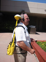 Guidance System with Haptic Pointer Interface.  This
figure includes half of the latest system, and includes the GPS receiver
and antenna carried in a small shoulder bag, together with the head
mounted electronic compass and stereo headphones.